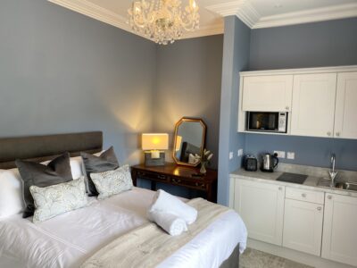 king bed with chandelier and bedside locker