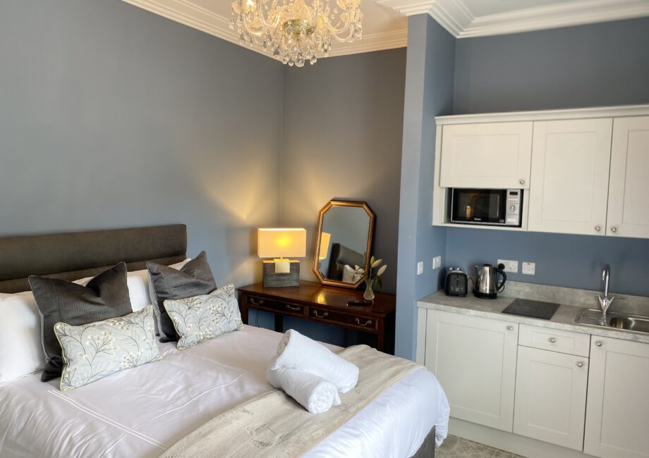 king bed with chandelier and bedside locker