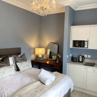 king bed with chandelier and bedside locker